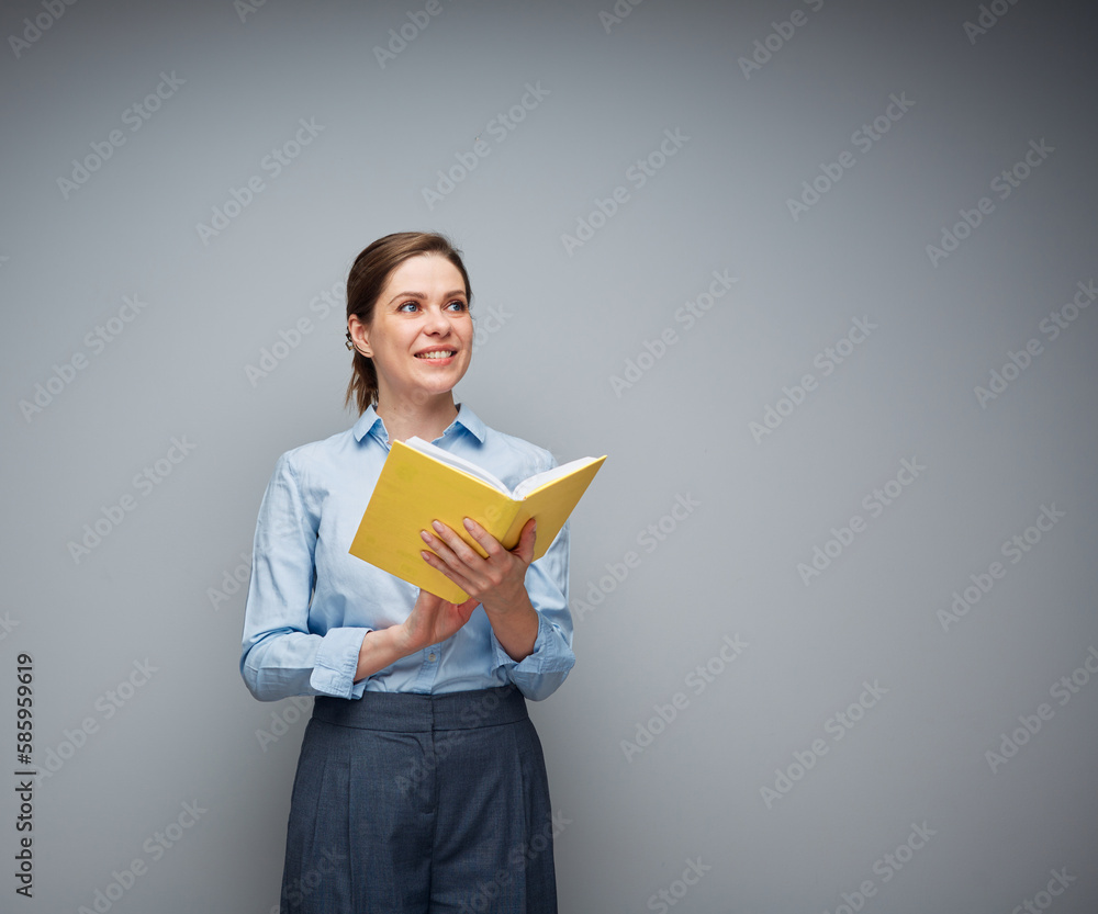 Smiling teacher or student girl, young woman holding open book and looking at side, female portrait.. Smiling teacher or student girl, young woman holding open book and looking at side, female portrait..