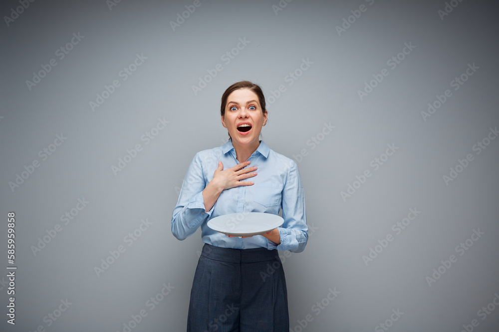 Surprising excited woman holding empty plate. Surprising excited woman holding empty plate.