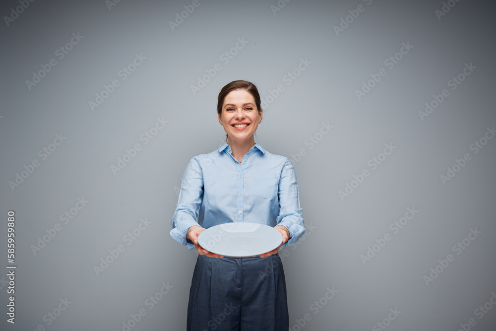 Smiling woman holding empty plate. Smiling woman holding empty plate.