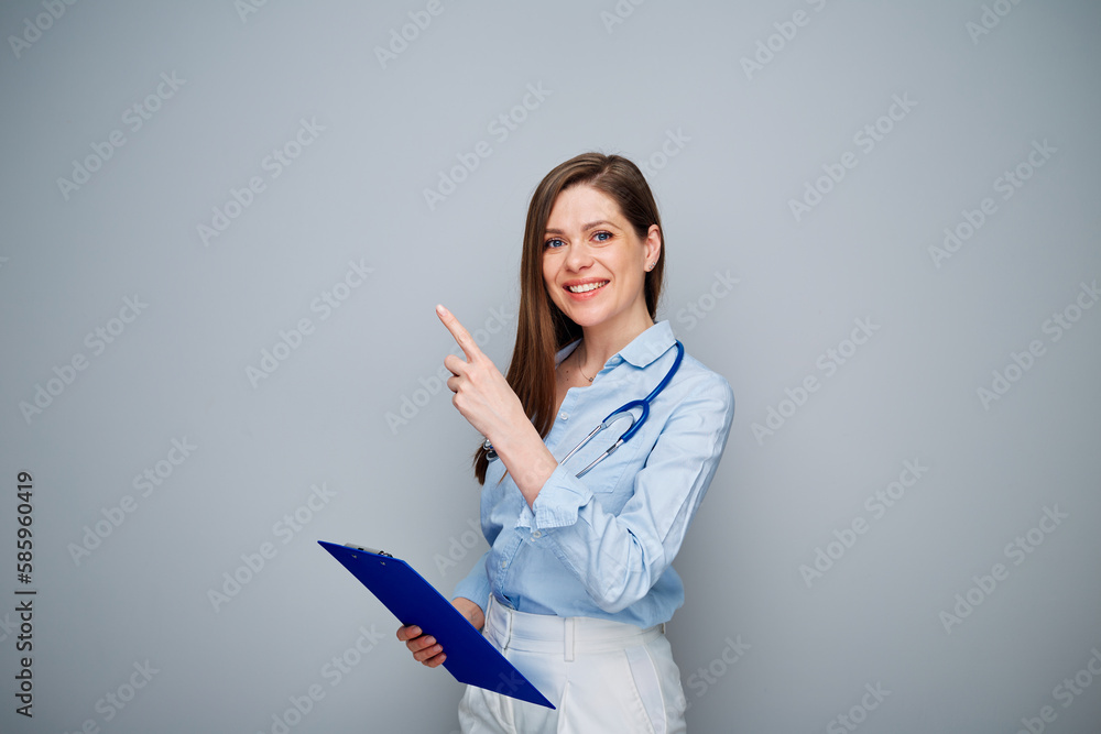 Smiling doctor woman pointing finger at side, isolated portrait with copy space. Smiling doctor woman pointing finger at side, isolated portrait with copy space.