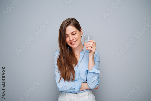 Smiling woman holding water glass looking at side.