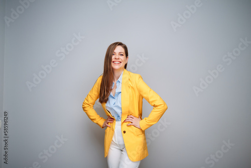 Happy business woman in yellow jacket on gray background