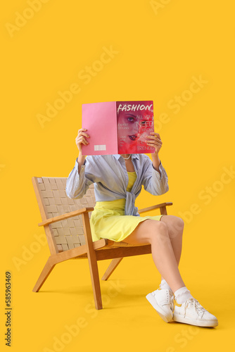 Young woman reading magazin...