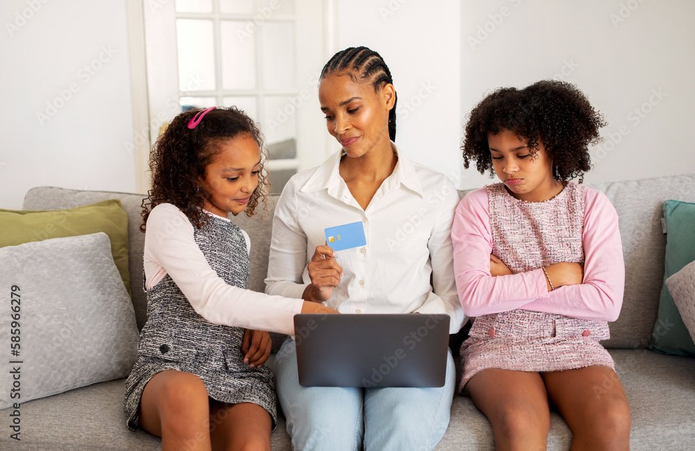 Black Girl Envying Shopping Online With Mother And Sister Indoor Black Girl Envying Shopping Online With Mother And Sister Indoor