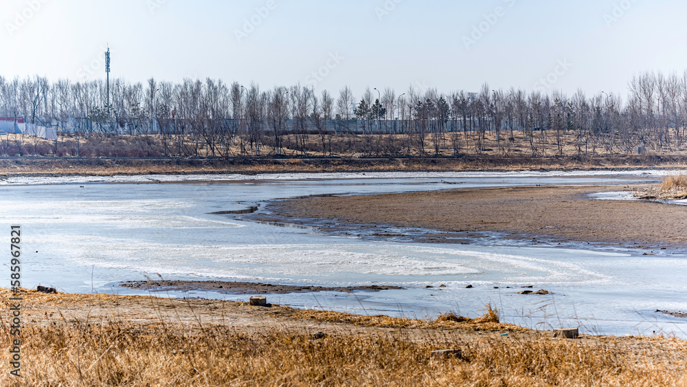 Landscape along the Yitong River in Changchun, China with melting ice and snow Landscape along the Yitong River in Changchun, China with melting ice and snow