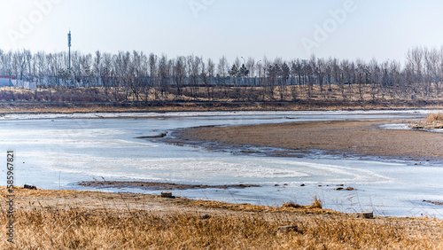 Landscape along the Yitong River in Changchun, China with melting ice and snow