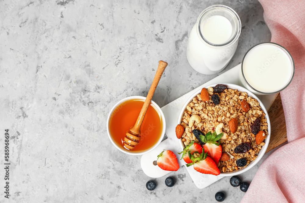 Bowls of tasty granola, honey, jug and glass with milk on grunge background Bowls of tasty granola, honey, jug and glass with milk on grunge background