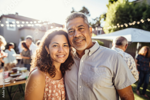 Portrait of mature Hispanic couple at family gathering outdoors in backyard in summer. photo