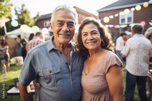 Portrait of mature Hispanic couple at large family gathering outdoors in backyard in summer. Generative AI. 