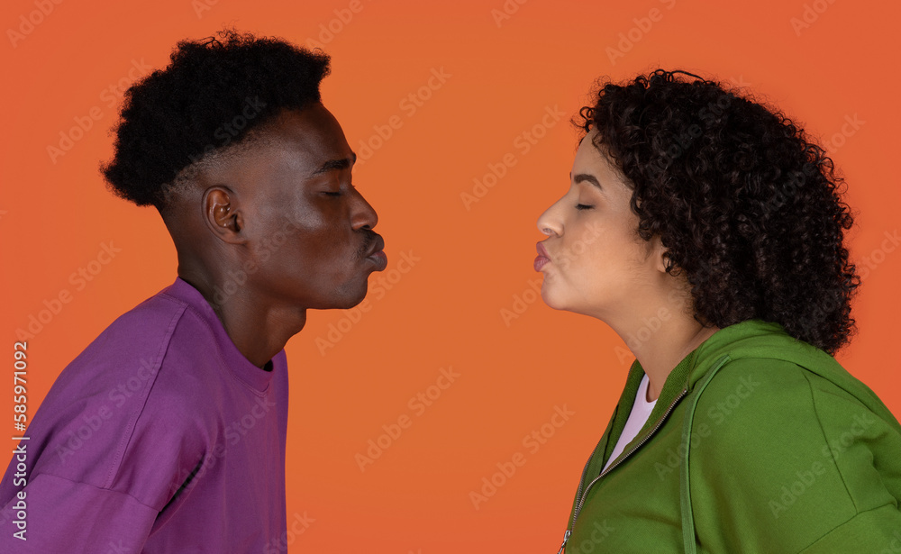 Closeup of interracial couple kissing on red, copy space Closeup of interracial couple kissing on red, copy space