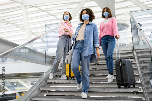 Group Of Women Wearing Protective Face Masks Walking On Stairs At Airport