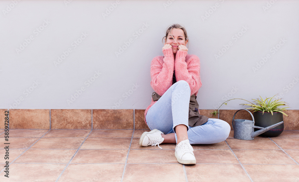 pretty young woman gardering and sitting on the floor outdoors pretty young woman gardering and sitting on the floor outdoors