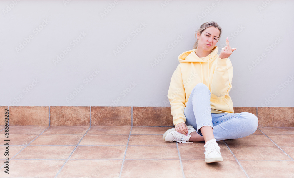 pretty caucasian sitting woman feeling angry, annoyed, rebellious and aggressive, flipping the middle finger, fighting back pretty caucasian sitting woman feeling angry, annoyed, rebellious and aggressive, flipping the middle finger, fighting back