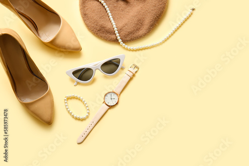 Stylish high heeled shoes and accessories on beige background