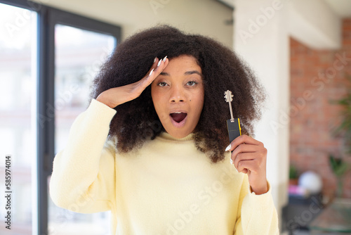 pretty afro black woman looking happy, astonished and surprised. new home key concept