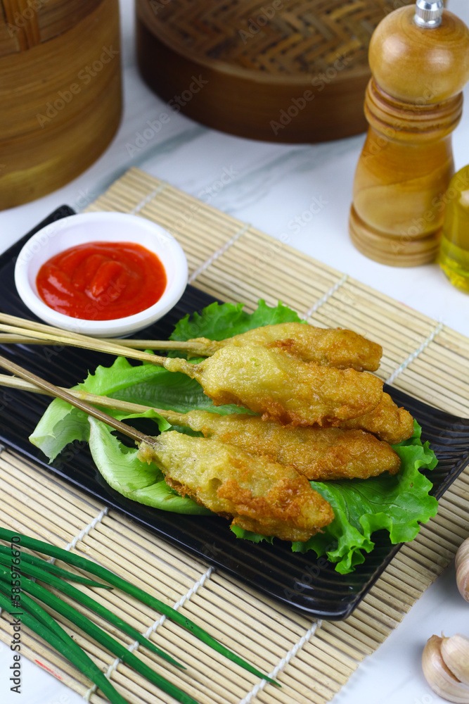 Sempol ayam or fried chicken satay, one ofpopular street food in Indonesia. Served with chili sauce. White marble background. Sempol ayam or fried chicken satay, one ofpopular street food in Indonesia. Served with chili sauce. White marble background.