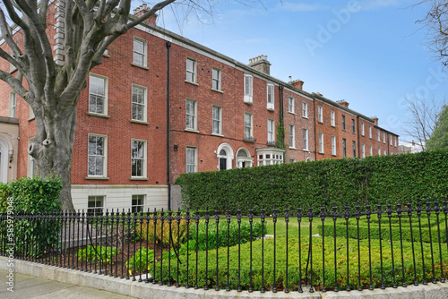 Photography Long row of three story brick townhouses with large front yards