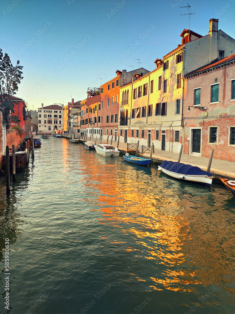 Obraz premium Central Venice, historic houses reflected in canal on a sunset, toned image. Get lost in the maze-like streets and admire the beautiful buildings, canals, and bridges.