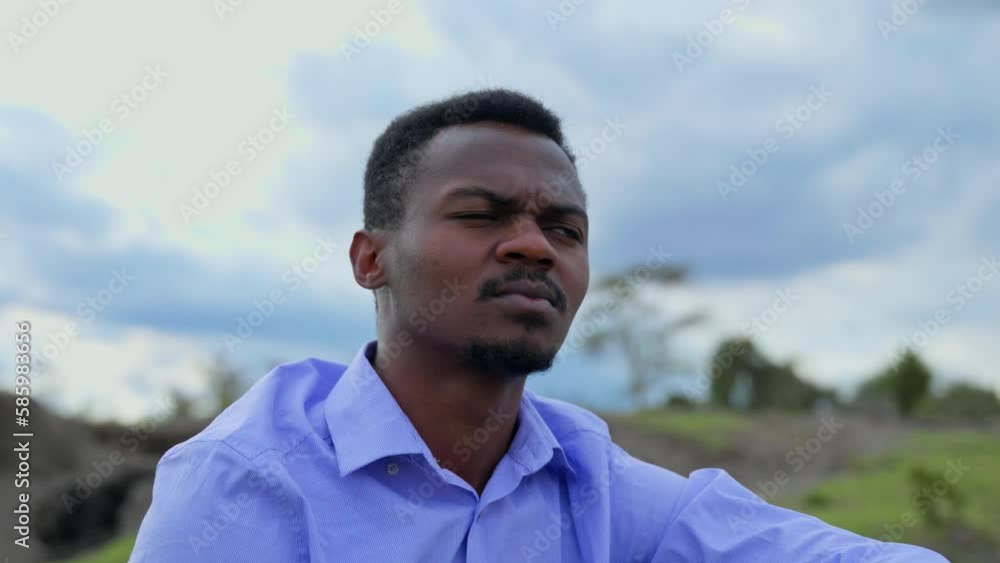 Young Black Guy Wearing Blue Shirt Looking Sad Sitting Out In Nature Young Black Guy Wearing Blue Shirt Looking Sad Sitting Out In Nature