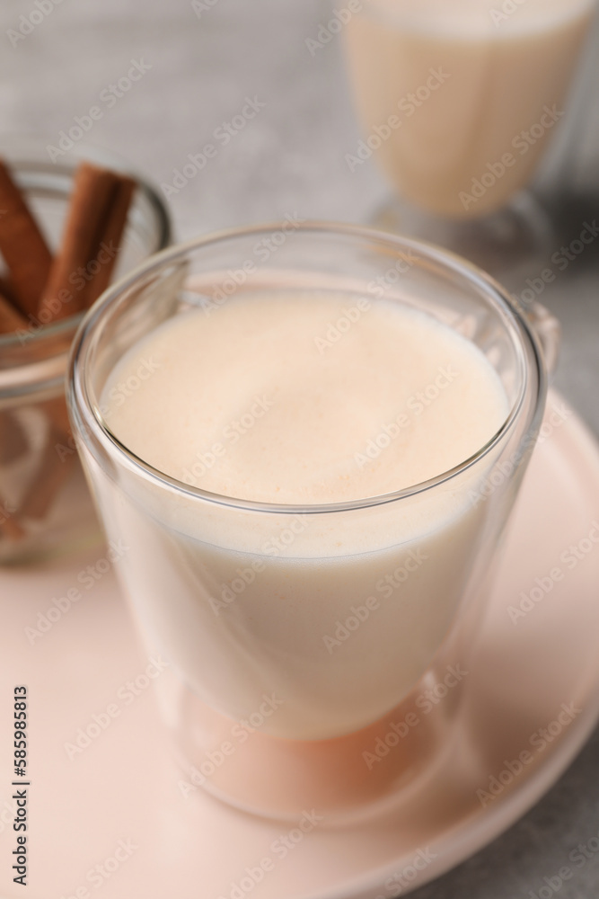Delicious eggnog with cinnamon on light grey table Delicious eggnog with cinnamon on light grey table
