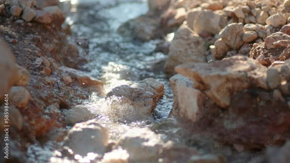 Close-up video of the purest transparent water in a mountain river flowing among the stones. Details of a sunny day in the mountains. Pure still clean water in a mountain spring Close-up video of the purest transparent water in a mountain river flowing among the stones. Details of a sunny day in the mountains. Pure still clean water in a mountain spring