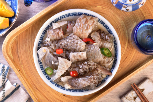 Cold fish skin in sauce in a bowl on a wooden table