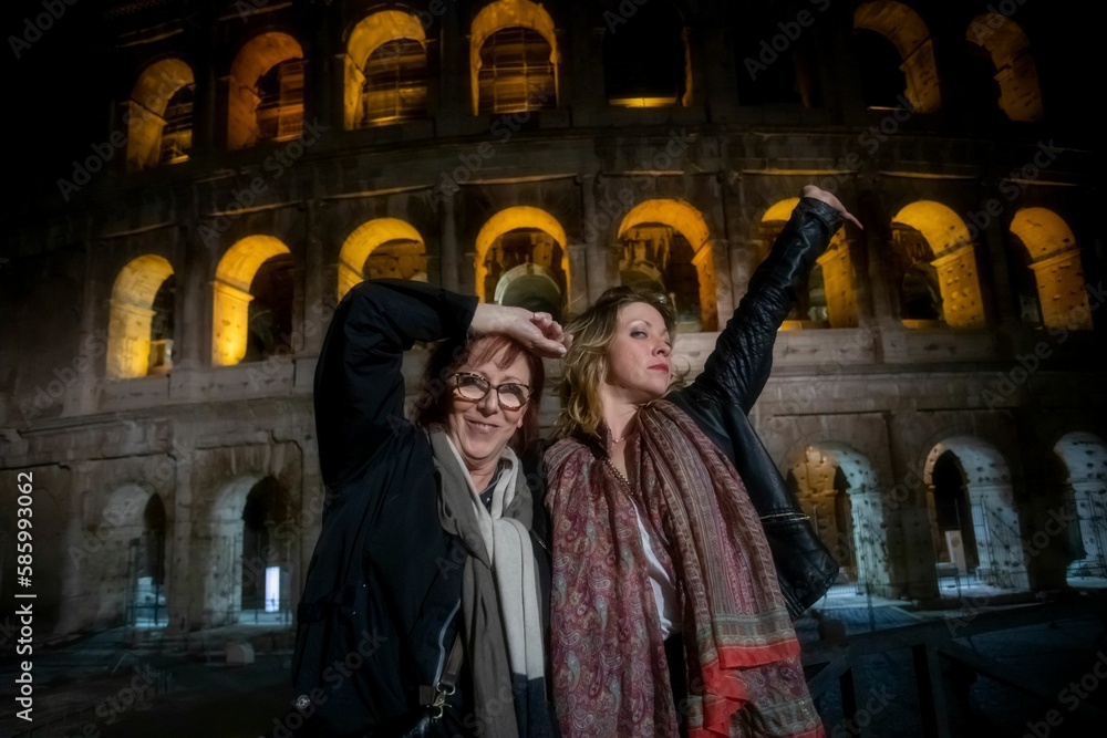 Naklejka premium Beautiful mother and daughter enjoying themselves in the evening at the Roman Colosseum