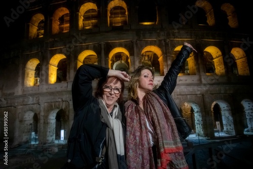 Beautiful mother and daughter enjoying themselves in the evening at the Roman Colosseum