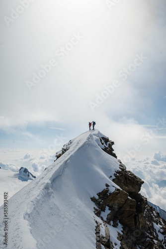 Aerial view of snow covered mountain landscape with people standing on edge photo