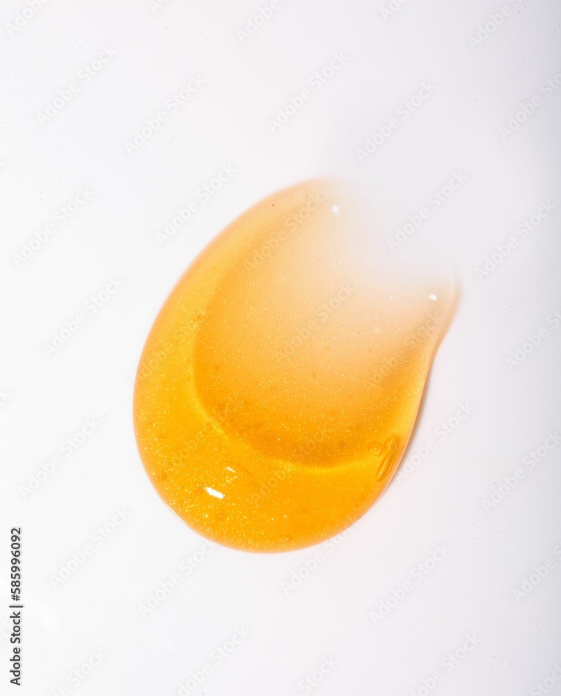 Vertical shot of a gold skincare texture on a white background