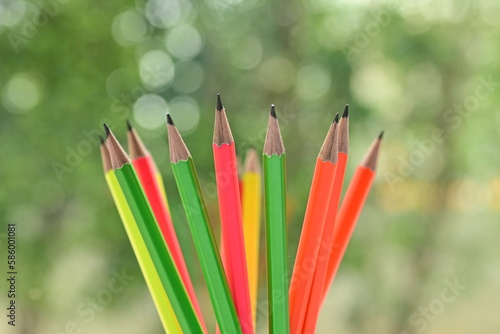group of colourful sharp pencil on blur green nature background with bokeh