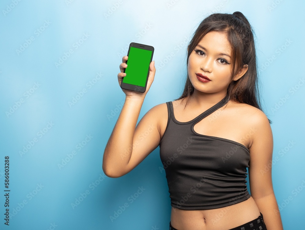 Cute philippine girl marketing a cell phone with a green screen against a blue background