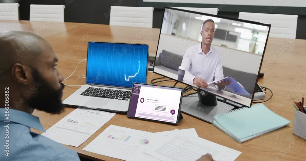 African american businessman in office using computer with video call and data processing on screen African american businessman in office using computer with video call and data processing on screen