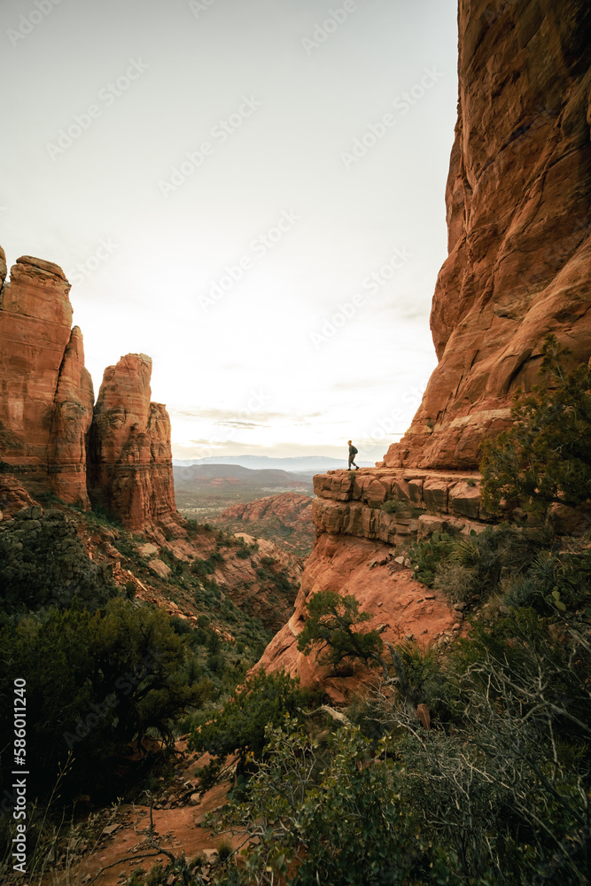 Wide angle view of woman watching sunset in Sedona Arizona from Cathedral Rock Viewpoint.