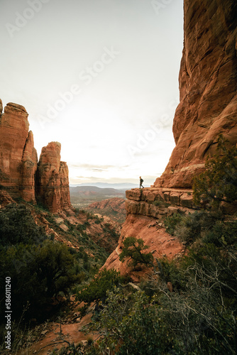 Wide angle view of woman watching sunset in Sedona Arizona from Cathedral Rock Viewpoint.