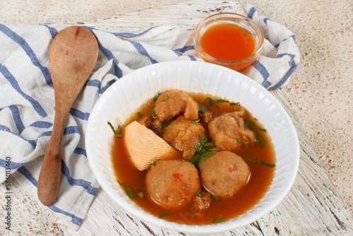 Bakso cuanki, Indonesian meatball soup, with tofu, and fish cracker, serve with chilly paste as a condiment.	 photo