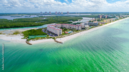 Drone Aerial View of Real Estate on Little Hickory Island in Bonita Spring, Florida with Gentle Wave Water in the Foreground and Bay Surrounded by Mangroves in the Background photo