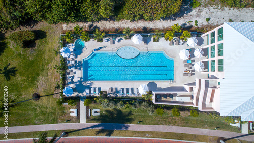 Cuadro en lienzo Aerial Drone View of Large Swimming Pool with Lush Landscaping and Umbrellas Nex