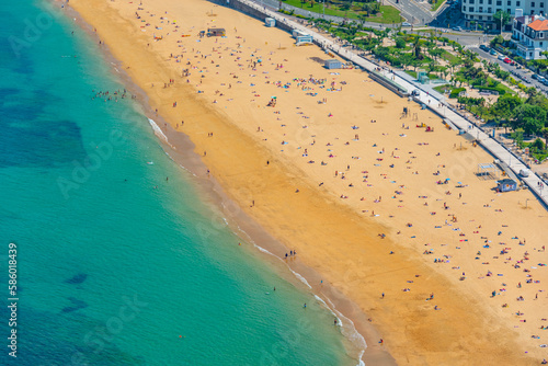 People are enjoying a sunny day at La Concha beach at San Sebastian, Spain photo