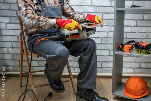 Worker with angle grinder. man repairing angle gringer at workshop. photo