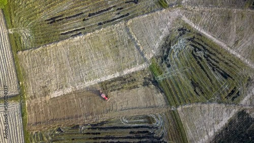 Aerial top view of tractor working in paddy field, Tractor field prepared for planting rice in spring.