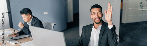 Fotografie Young worker raise his hand up to ask a question to business team leader