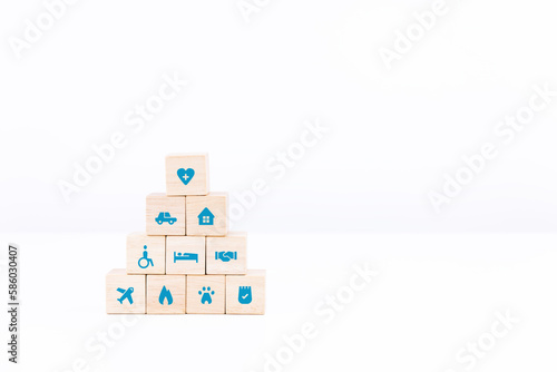 Wooden block stacking on white table and background. healthcare and insurance icon on wood cube arranged in a pyramid. copy space and isolated.