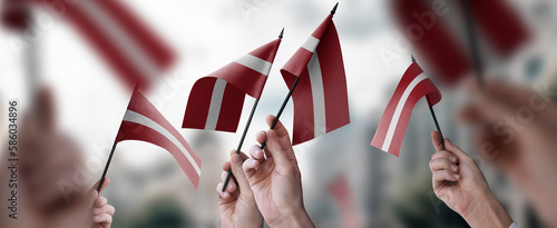 Canvastavla A group of people holding small flags of the Latvia in their hands