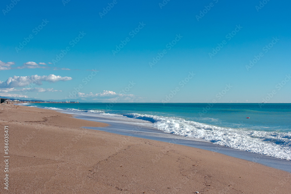 Small waves on sandy beach and blue sky no clouds in Manavgat Turkey