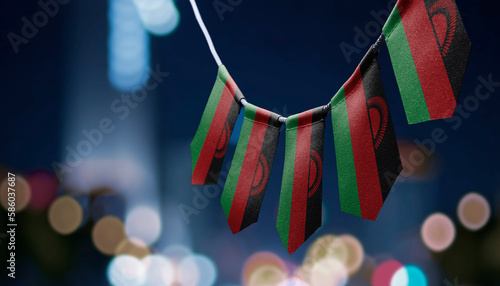 A garland of Malawi national flags on an abstract blurred background