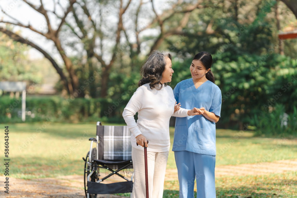 Young asian care helper with asia elderly woman on wheelchair relax together park outdoors to help and encourage and rest your mind. using crutches and cane help support yourself to walk Young asian care helper with asia elderly woman on wheelchair relax together park outdoors to help and encourage and rest your mind. using crutches and cane help support yourself to walk