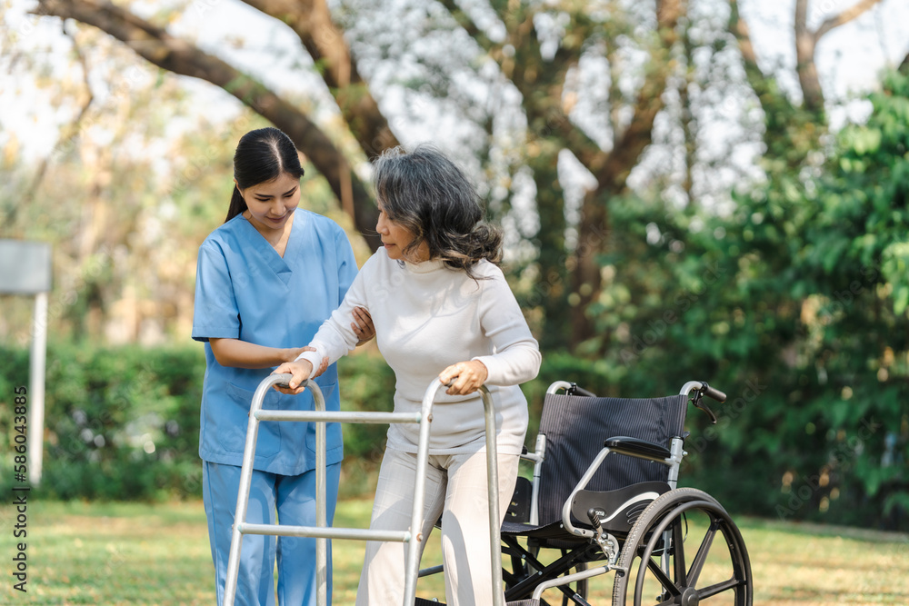Young asian care helper with asia elderly woman on wheelchair relax together park outdoors to help and encourage and rest your mind with green nature. Help support yourself to learn to walk. walker Young asian care helper with asia elderly woman on wheelchair relax together park outdoors to help and encourage and rest your mind with green nature. Help support yourself to learn to walk. walker