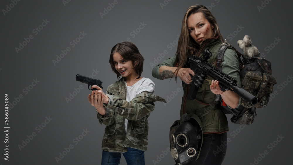Portrait of woman and smiling young girl survivors with rifle and handgun. Portrait of woman and smiling young girl survivors with rifle and handgun.