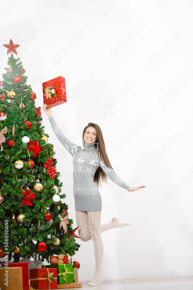 Portrait of happy young woman christmas present boxes in front of christmas tree Portrait of happy young woman christmas present boxes in front of christmas tree